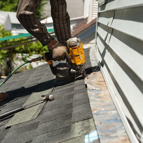 Roofer from Roofing Guys Brisbane using nail gun to carry out emergency roof repairs on a storm-damaged roof. Roofer from Roofing Guys Brisbane using nail gun to carry out emergency roof repairs on a storm-damaged roof.