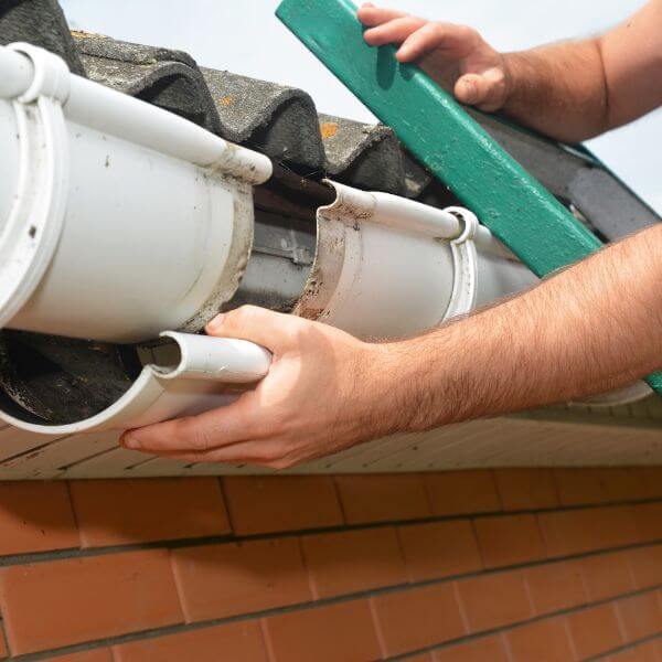 Roofing Guys Brisbane carrying out gutter repairs on a tiled roof. We fix cracked, leaking, and rusted gutters with professional replacements and maintenance services.