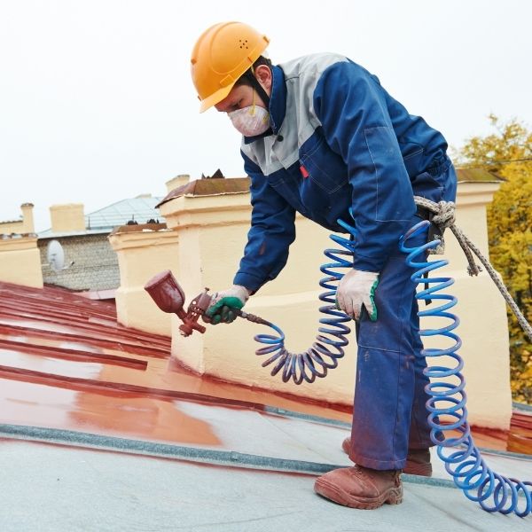 Roofing Guys Brisbane roof painting, expert roof painter applying durable paint finish on metal roof.